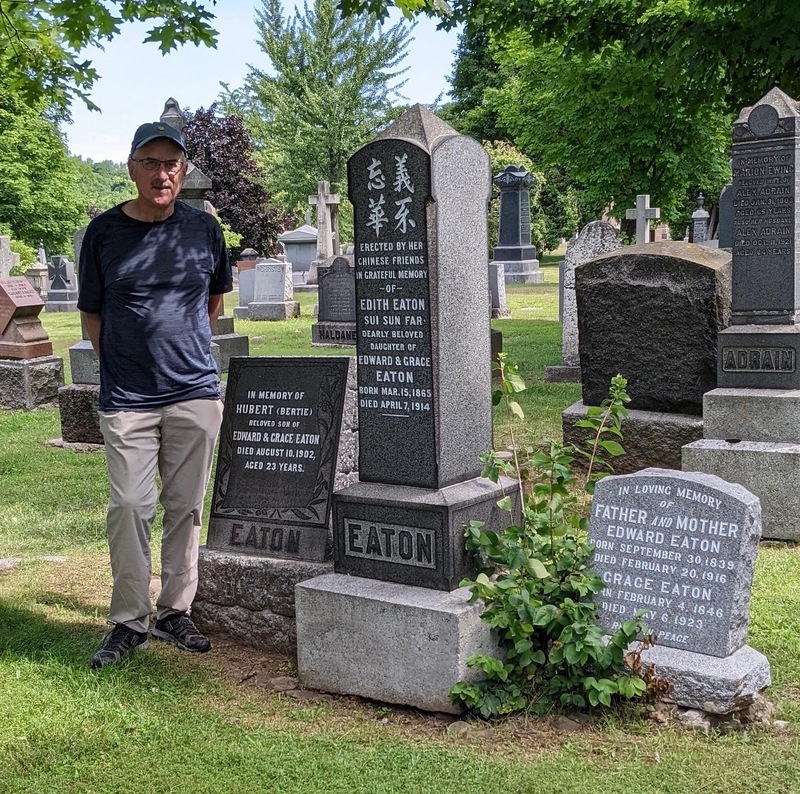 A photo of Edith Eaton's gravestone at Mount Royal Cemetery in Montreal; pictured with Eaton family descendant Frank Rooney.