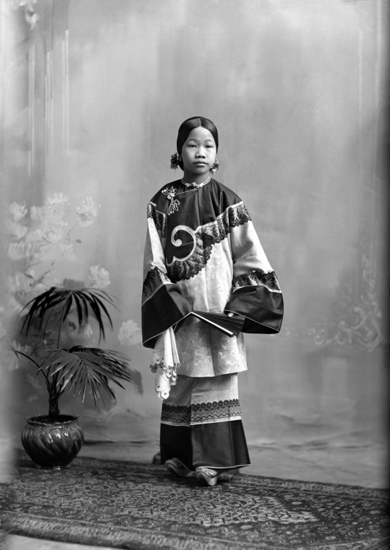 A photograph identifying a "Miss Sang Kee." It is unclear whether she is the slave girl referenced by Sui Sin Far in "Girl Slave in Montreal" in 1894 though the dates suggest a possibility. The McCord museum dates this photograph as 1897, the same time as "Mrs. Sang Kee and children," which also shows Georgie Sang Kee (the oldest Sang Kee child) as a toddler. 